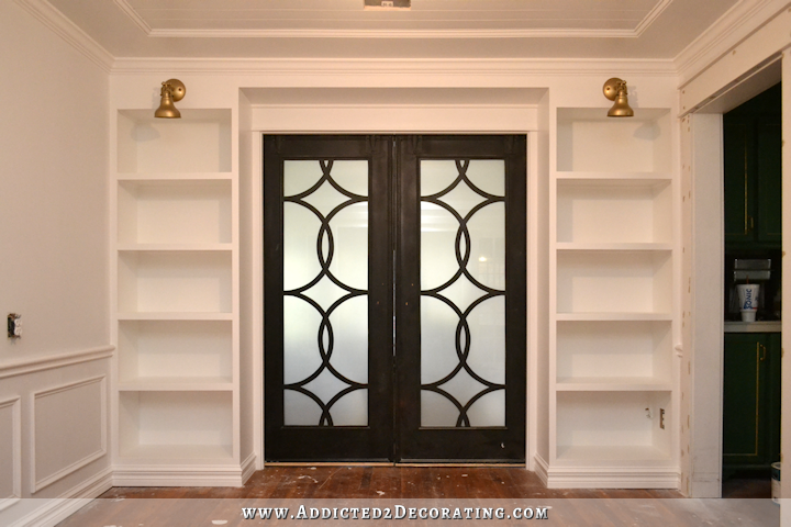 music room pocket door bookcases with brass sconces - 1